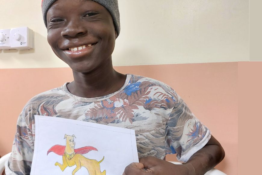 Child holding a drawing of a dog
